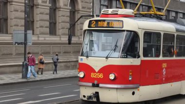 Prag, Çek Cumhuriyeti 27 Şubat 2026: Klasik kırmızı tramvay 4K yavaş çekimde şehir kavşağında kameraya yaklaşırken çekildi. Bu 4K hisse senedi görüntüsü herhangi bir Prag editör projesi için tam olarak ihtiyacınız olan şey.