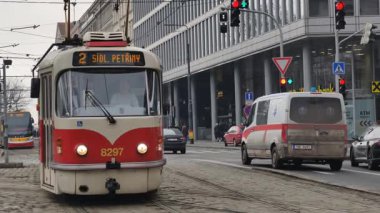 Prag, Çek Cumhuriyeti 27 Şubat 2026: Klasik kırmızı tramvay 4K yavaş çekimde şehir kavşağında kameraya yaklaşırken çekildi. Bu 4K hisse senedi görüntüsü herhangi bir Prag editör projesi için tam olarak ihtiyacınız olan şey.