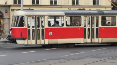 Prag, Çek Cumhuriyeti 27 Şubat 2026: Klasik kırmızı tramvay 4K yavaş çekimde şehir kavşağında kameraya yaklaşırken çekildi. Bu 4K hisse senedi görüntüsü herhangi bir Prag editör projesi için tam olarak ihtiyacınız olan şey.