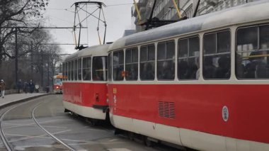 Prag, Çek Cumhuriyeti 27 Şubat 2026: Klasik kırmızı tramvay 4K yavaş çekimde şehir kavşağında kameraya yaklaşırken çekildi. Bu 4K hisse senedi görüntüsü herhangi bir Prag editör projesi için tam olarak ihtiyacınız olan şey.