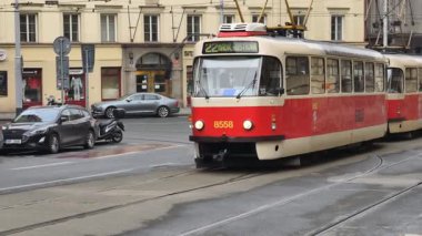 Prag, Çek Cumhuriyeti 27 Şubat 2026: Klasik kırmızı tramvay 4K yavaş çekimde şehir kavşağında kameraya yaklaşırken çekildi. Bu 4K hisse senedi görüntüsü herhangi bir Prag editör projesi için tam olarak ihtiyacınız olan şey.