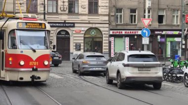 Prag, Çek Cumhuriyeti 27 Şubat 2026: Klasik kırmızı tramvay 4K yavaş çekimde şehir kavşağında kameraya yaklaşırken çekildi. Bu 4K hisse senedi görüntüsü herhangi bir Prag editör projesi için tam olarak ihtiyacınız olan şey.