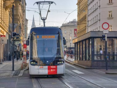 Prag, Çek Cumhuriyeti 6 Mart 2026: Prag 'da merkez bir cadde boyunca, yayalar tarihi Avrupa binaları arasındaki kaldırımlar boyunca yürürken yolcularla birlikte seyahat eden tramvay. Toplu taşımacılık
