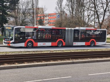 Prag, Çek Cumhuriyeti, 9 Mart 2026 Prag Entegre Ulaşım Sistemi 'nin açık otobüsleri, kapalı bekleme alanından ve yakınlardaki kentsel trafikten geçen yolcuların bulunduğu bir otobüs durağında durmaktadır..