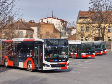 Prag, Çek Cumhuriyeti, 9 Mart 2026 Prag Entegre Ulaşım Sistemi 'nin açık otobüsleri, kapalı bekleme alanından ve yakınlardaki kentsel trafikten geçen yolcuların bulunduğu bir otobüs durağında durmaktadır..