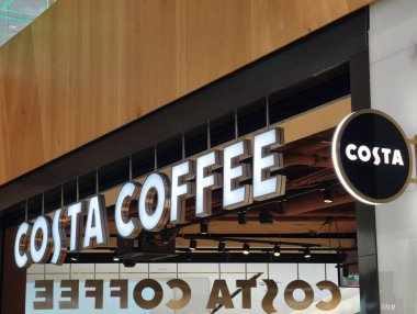 Prag, Çek Cumhuriyeti, 12 Mart 2026 Costa Kafe tabelası ve bir alışveriş merkezinin logosu. İş saatleri içinde ticari bölgede bir perakende mağaza girişinin editör fotoğrafçılığı.