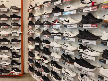 Prag, Çek Cumhuriyeti - 20 Mart 2026: Raflarda uluslararası spor markalarının en ünlü ve modaya uygun spor ayakkabıları koleksiyonunun sergilendiği geniş bir ayakkabı mağaza duvarı manzarası. Modern perakendecilerin gazetecilik bakış açısı