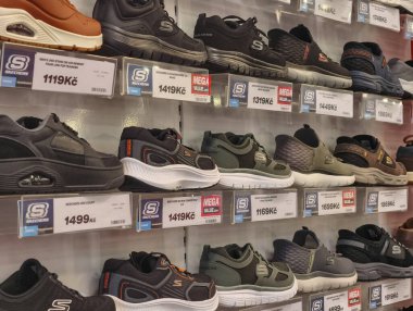 Prague, Czech Republic - March 20, 2026: A wide interior view of a shoe store wall displaying a vast collection of the most famous and fashionable sneakers from international sports brands on shelves. A journalistic perspective of the modern retail