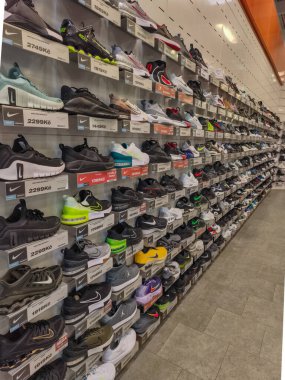 Prag, Çek Cumhuriyeti - 20 Mart 2026: Raflarda uluslararası spor markalarının en ünlü ve modaya uygun spor ayakkabıları koleksiyonunun sergilendiği geniş bir ayakkabı mağaza duvarı manzarası. Modern perakendecilerin gazetecilik bakış açısı