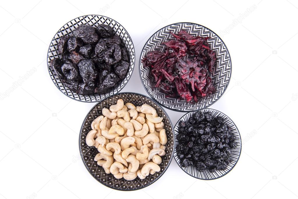 Bowls with dried blueberries, plums, hibiscus and cashews