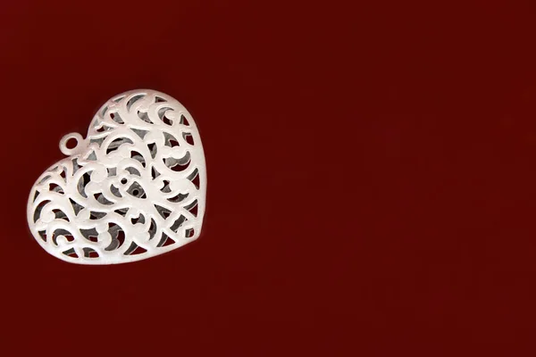 Metal heart on red background — Stock Photo, Image