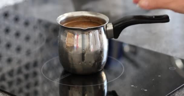 香りトルココーヒーを作る。女性の手は誘導調理器にコーヒーとcezvaを置きます — ストック動画