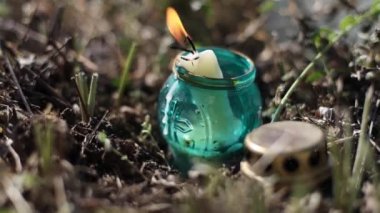 Mezarlıkta yanan bir mumla eski bir mezar feneri.