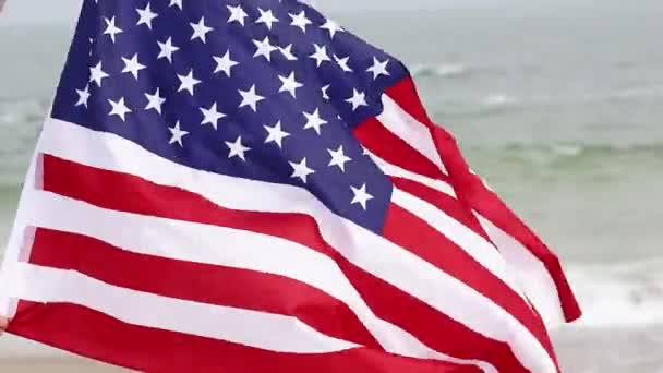 Amerikaanse vlag waait in de wind op zee achtergrond. Amerikaanse vlag. Memorial Day, Amerikaans concept. — Stockvideo