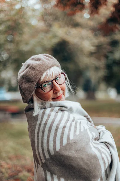 Φθινόπωρο κάθετη φωτογραφία του ευτυχισμένη Καυκάσια κυρία σε κομψό μπερέ, ζεστή κουβέρτα σε μια βόλτα σε μια θυελλώδη μέρα το φθινόπωρο ή το φθινόπωρο — Φωτογραφία Αρχείου