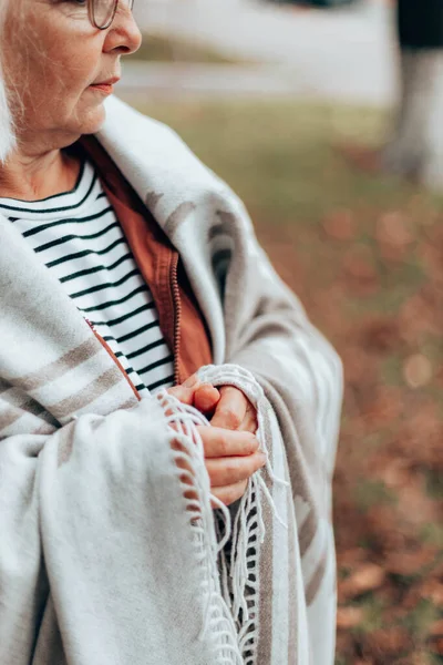 Otoño foto vertical de una mujer envuelta en una acogedora manta de lana caminando en el bosque de otoño —  Fotos de Stock