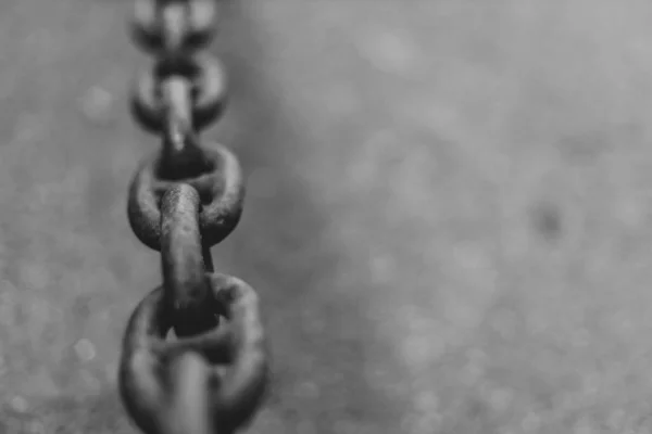 Черная металлическая цепь на асфальтовом фоне с копировальным пространством — стоковое фото