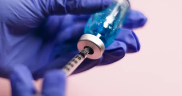 Médecin ou infirmière mains en gants bleus tenant la seringue du vaccin dose d'injection hypodermique pour la prévention maladie à virus de la maladie de traitement immunitaire — Video