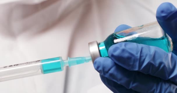 Ärztin Hand in blaue medizinische Handschuhe mit Coronavirus, Covid-19-Virus, Impfflasche — Stockvideo