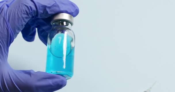 Artsen of verpleegkundigen in blauwe handschoenen met de vaccinampul tegen coronavirus, influenza of mazelen, injectiespuit voor het vaccineren van een kind — Stockvideo