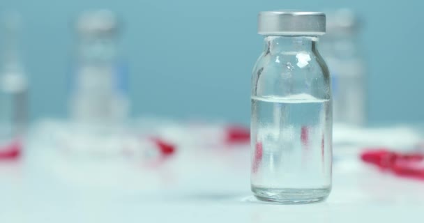 Anesthesist arts hand in beschermende medische handschoenen en anesthesie vloeibare fles op witte tafel lab — Stockvideo
