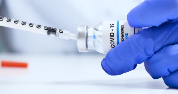 Main de médecin féminine avec flacon transparent de vaccin contre le coronavirus liquide et seringue injectable en laboratoire. Recherche et développement d'un nouveau remède aux maladies — Video