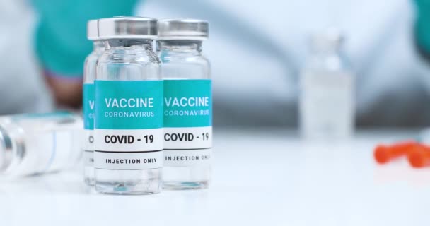 Médecin en gants de caoutchouc bleu latex appliquant le vaccin contre le coronavirus dans la seringue pendant la pandémie de coronavirus, CoV-SRAS, COVID-19 — Video