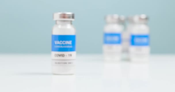 Coronovirus, vaccinazione della popolazione con covid-19. Flacone di vaccino SARS-CoV-2 vetro e siringa su tavolo da laboratorio bianco con copyspace. Movimento della fotocamera liscio — Video Stock