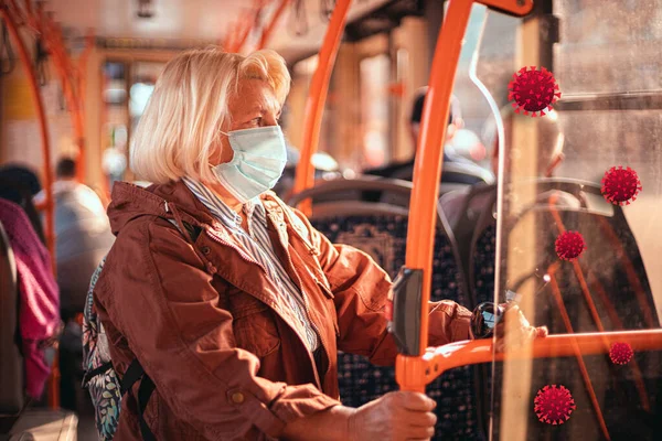 Felnőtt szőke 50 éves nő orvosi védőmaszkot visel a tömegközlekedésben a járvány idején. — Stock Fotó