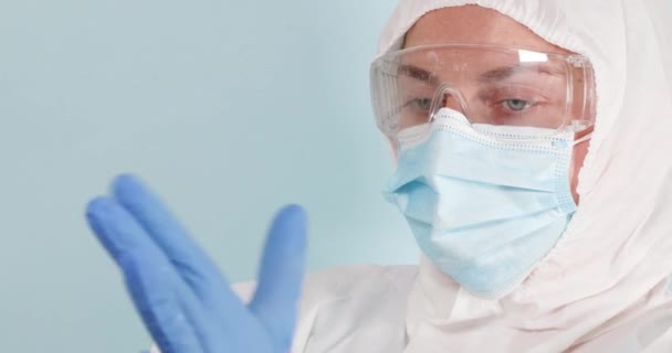Femme médecin met sur l'équipement de protection individuelle pendant la pandémie de coronavirus — Video