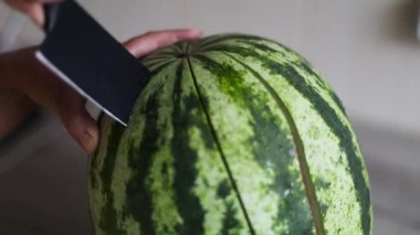 Mutfakta karpuz kesen kadınların ellerini kapatın.