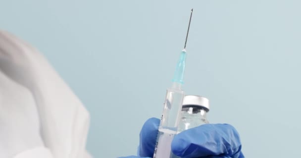 Close-up van een arts of beroepsbeoefenaren in de gezondheidszorg die een coronavirus, mazelen- of griepvaccin en een injectiespuit in hun handen hebben. Geneeskunde, wetenschap en gezondheidszorg — Stockvideo