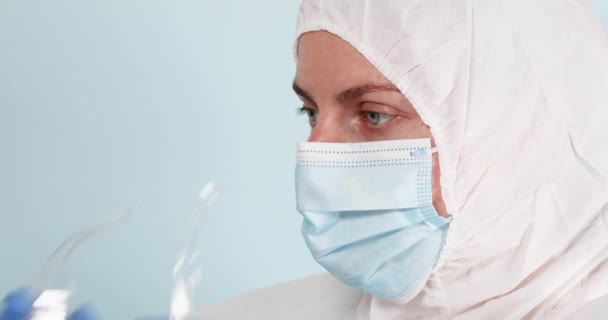 Female doctor or nurse puts safety glasses on her face to protect against coronavirus infection — Stock Video