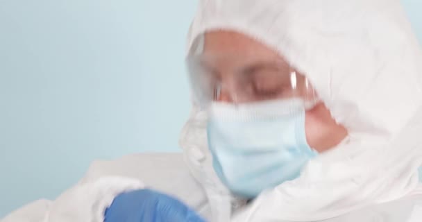 Γυναίκα γιατρός βάζει σε μέσα ατομικής προστασίας κατά τη διάρκεια της πανδημίας coronavirus — Αρχείο Βίντεο
