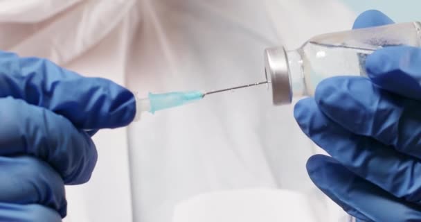 Doctor in latex blue rubber gloves holding tube with nCoV Coronavirus vaccine for 2019-nCoV COVID virus. — Stock video