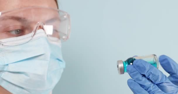 Ręka lekarza w niebieskich rękawiczkach nitrylowych zawierających szczepionkę przeciw grypie, odrze, koronawirusowi do szczepienia niemowląt i dorosłych — Wideo stockowe