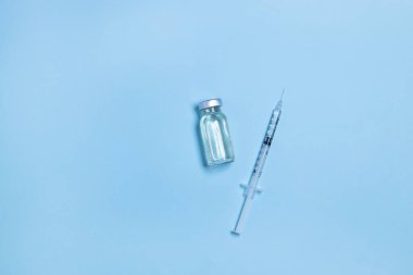 Coronavirus, grip ya da kızamık aşısı şişesi mavi arka planda şırınga, fotokopi alanı olan yatay pankart. Aile bağışıklığı kavramı. Asgari biçim