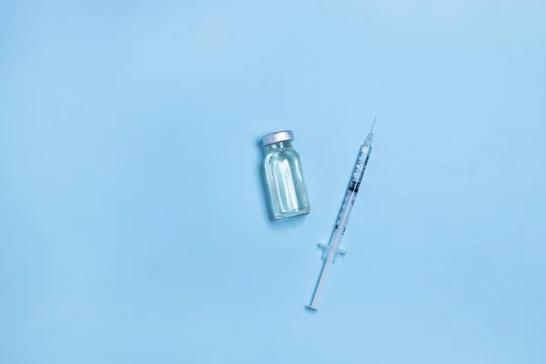 青の背景に注射器を備えたコロナウイルス インフルエンザまたは麻疹ワクチンバイアル コピースペースのある水平方向のバナー 家族の予防接種の概念 ミニマルスタイル — ストック写真