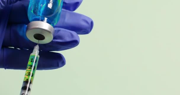 Close-up van de hand in latex blauwe beschermende handschoenen houdt yringe tijdens injectie drugs of medicijnen. — Stockvideo