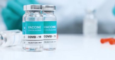 Doktor Coronavirus aşısı için bir şırınga aldı. Aşı şişeleri beyaz laboratuvar masasında. Genel Aşılama.