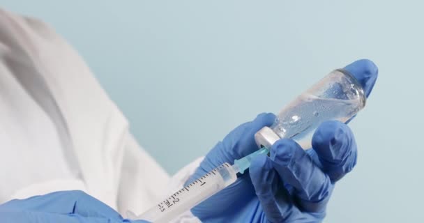 Close up of doctor hands holding coronavirus vaccine and seringa in clinic during the coronavirus pandemic, SARS-CoV, COVID-19 — Vídeo de Stock