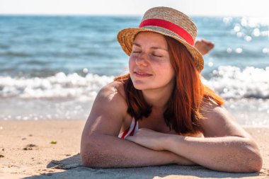 Kumsalda yatan genç bir kadın. Rahatlama kavramı