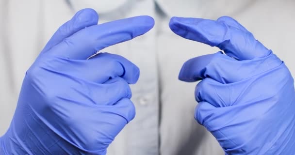 Врач или медсестра надевают голубые нитриловые хирургические перчатки, профессиональную медицинскую безопасность и гигиену — стоковое видео