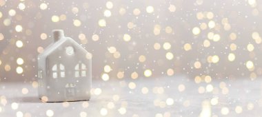 Oyuncak model ev ve beyaz yatay arkaplan üzerindeki bulanık ışık kopya alanı ile