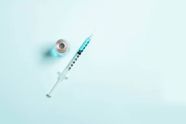 隔離された青い固体の背景に青い薬液でシリンジ 予防接種 免疫または美容の概念 — ストック写真