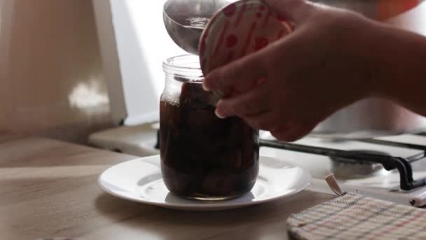 La mano femenina vierte salmuera y adoba o fermenta hongos Armillaria mellea en un frasco de vidrio. — Vídeos de Stock