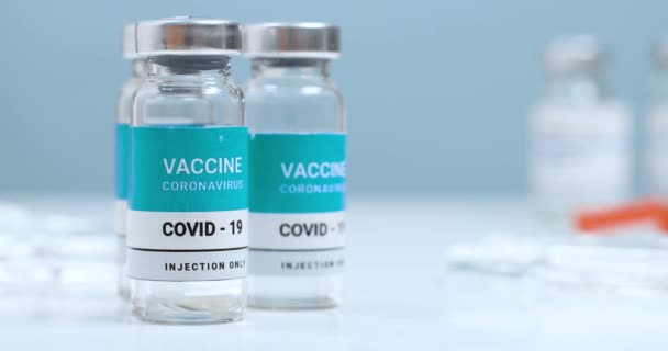 Chiusura dei flaconcini trasparenti di vaccino per iniezione di covid 19 contro il coronavirus. Il medico prende il flacone del medicinale — Video Stock