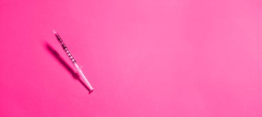 Fotokopi alanı olan minimalist pembe bir arka planda havada keskin bir iğneyle tıbbi şırınga. Yüz yaşlanma, gençleştirme ve nemlendirici prosedürler. Estetik kozmetoloji.