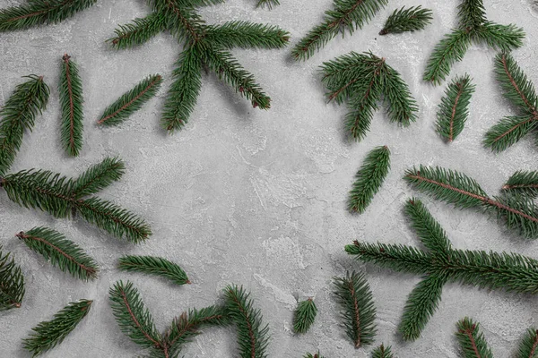 Natale e Capodanno cornice sfondo vacanza. Telaio rami di abete rosso sempreverde su sfondo grigio cemento. Tema flat lay, vista dall'alto, spazio di copia — Foto Stock