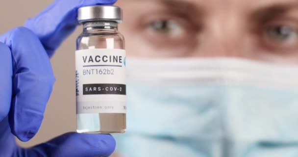 Odessa, Ukraine - 9 décembre 2020 : Flacon de vaccin contre le coronavirus entre les mains de médecins dans une clinique. Mise au point et essai d'un nouveau médicament BNT162b2 Pfizer Biontech contre la pandémie de COVID-19 — Video